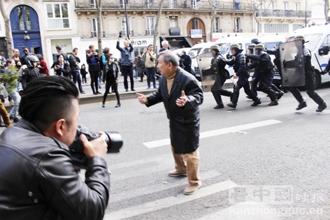 站在亚裔青年和警察之间的华人长者。(摄影：林莲怡、李牧/看中国)