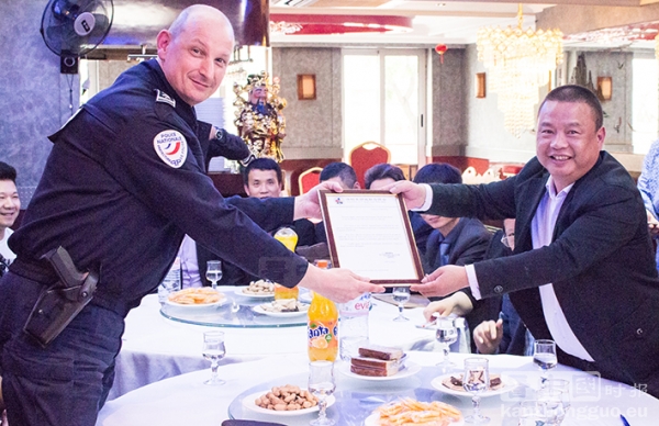 巴黎20区警察局长赫贡接过法国美丽城联合商会会长姜金玉手中的感谢信。 (摄影：林莲怡/看中国)