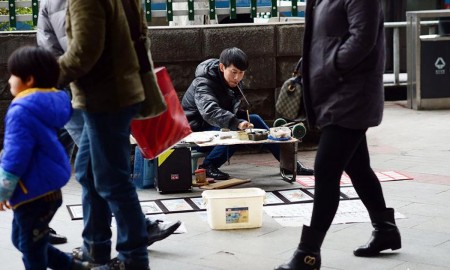 张启辉将自己的作品摆在街边的摊上出售。(网络图片)