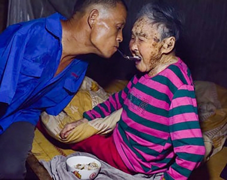 陈星银嘴里叼勺喂91岁母亲（网络图片）