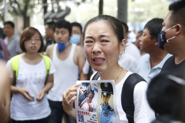 天津爆炸事故中，一名失踪消防员的家属向当局抗议。(AFP/Getty Images)
