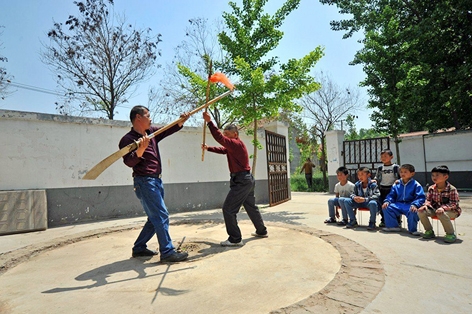 姬庄村村民经常聚集在村大院演练武术，孩子在一旁观看。（网络图片）