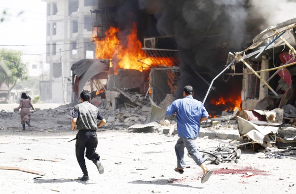 叙利亚政府军轰炸反政府军控制区域，一男子从废墟和血迹旁跑过。（AFP/Getty Images）