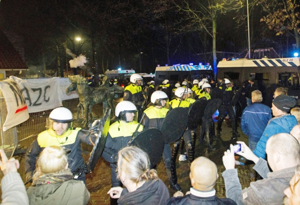 16日，荷兰海尔德马尔森小镇，有关开设难民中心讨论会召开场地前，警方阻止前来抗议的人们。（AFP/Getty Images）