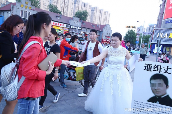 丁珍站穿着婚纱，站在街头“通缉”丈夫。(网络图片)