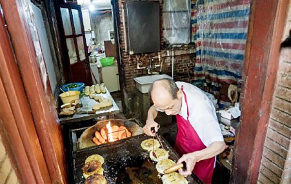 “阿大葱油饼”店主吴根存成为舆论关注的焦点。（网络图片）