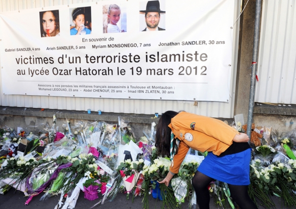 2012年，一位女性在图卢兹的犹太学校门口为恐袭中的遇难者鲜花。（AFP/Getty Images）