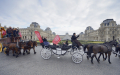 法国马展参展者驾着马车在卢浮宫前经过