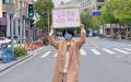 上海市一名戴着口罩的短发女子高举“言论自由 ”的纸牌（网络图片）