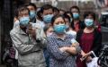 由于中共的推波助澜，导致湖北人备受歧视，甚至遭到驱赶。图为2020年5月15日，武汉市的一条街道上居民们排队等候病毒筛检。（图片来源：STR/AFP via Getty Images）