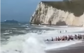 日前，英国杜德尔门逾30人牵一线，拉回巨浪冲走泳客。（图片来源：视频截图)