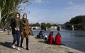 戴着口罩的行人在巴黎塞纳河边路过，背后是艺术桥和新桥。（Chesnot/Getty Images）