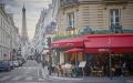 2021年5月19日，巴黎市区一家餐馆迎来在露台就餐的顾客，街道尽头的背景是埃菲尔铁塔。（Kiran Ridley/Getty Images）