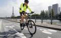 一名男子在巴黎埃菲尔铁塔附近沿塞纳河新建成的自行车道上骑自行车。（Chesnot/Getty Images）