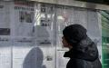 2022年2月24日，北京一名男子在街道旁阅读中共官方报导的关于俄罗斯与乌克兰冲突事件。（图片来源：JADE GAO/AFP via Getty Images）