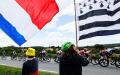 环法自行车赛的支持者手举法国国旗和布列塔尼旗帜（右）。（THOMAS SAMSON/AFP via Getty Images）