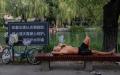 2022年7月7日北京高温天气，市民湖里游泳、湖边纳凉。（图片来源：Getty Images）