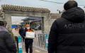 2022年12月20日北京疫情肆虐，男子捧着亲人骨灰走出殡仪馆。（Getty Images）