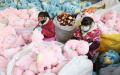 2022年12月15日，二名工人在中国东部江苏省连云港的一家工厂生产毛绒玩具。（图片来源：STR/AFP via Getty Images）
