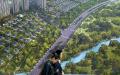 图为中国消费者路过一张巨幅房地产海报。（Hong Wu / Getty Images）