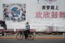 2018年5月29日，辽宁丹东的一位路人骑自行车经过一副中国梦的标语牌。（图片来源：FRED DUFOURAFP via Getty Images）