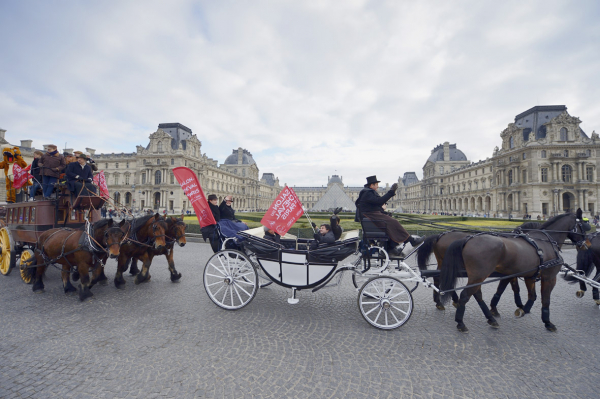 法国马展参展者驾着马车在卢浮宫前经过
