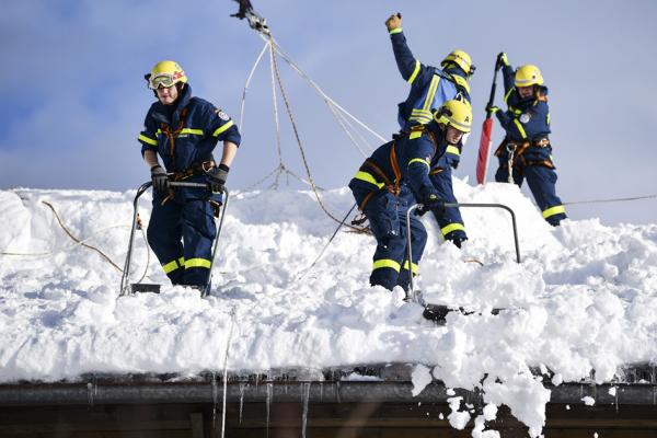 1月12日，德国工人在铲除房顶积雪。（Getty Images）