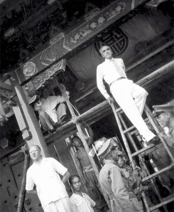 图为1926年，燕京大学启用新校区，校长司徒雷登在正门(西大门)前亲自登梯揭校匾。当时校门是按照王府大门规制修建的，蔡元培题匾。