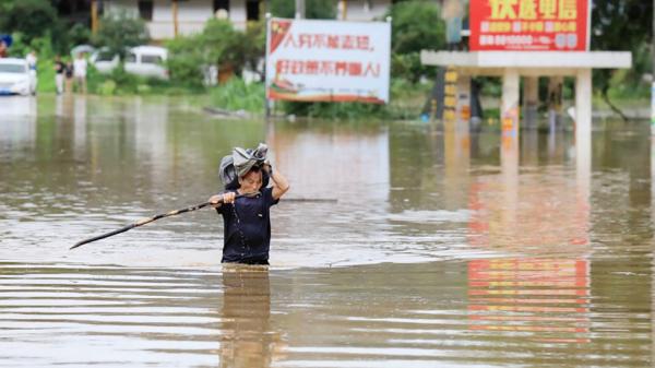 2019年6月9日一名男子在暴雨袭击后于广西的融安趟洪水。(AFP/Getty Images)  