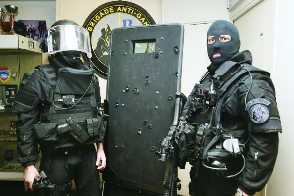 两名法国精英特警队BRI警队队员与布满弹孔的在巴塔克兰剧院恐袭案中使用过的防爆盾牌。（AFP/Getty Images）