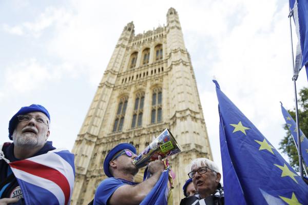 尽管强硬战略遭遇挫败，约翰逊5日仍坚称英国必须在10月31日离开欧盟。图为2019年9月5日，伦敦议会大厦外面出现的带有横幅和欧盟旗帜的反英国退欧运动人士。（AFP/Getty Images）