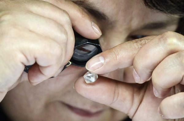 一名俄罗斯员工在钻石分拣中心检查了未经加工的钻石。（AFP/Getty Images）