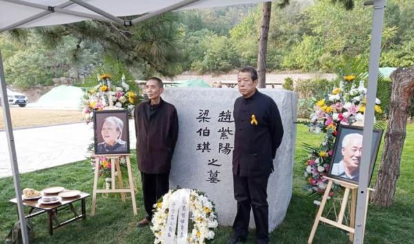 10月18日，赵紫阳夫妇墓碑前摆放着出席骨灰安葬仪式的亲友们献的鲜花。赵紫阳之子赵二军（右）立于碑前。（美国之音）