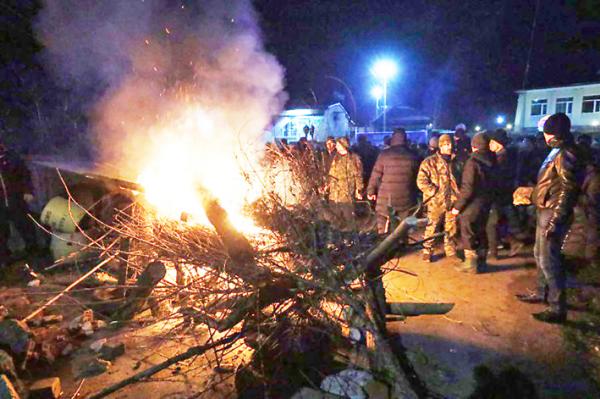 2月20日，乌克兰抗议者放火点燃轮胎，并设置路障，他们不满政府将撤回的侨民安置在他们居住的地方。   (Getty Images)