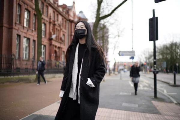 一名戴口罩的女子走在大街上。（Getty Images）