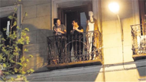 马德里的居民在自家阳台上交谈。  (Getty Images)