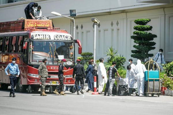 4月24日，巴基斯坦安全人员护送一辆载有国际旅行者的巴士抵达旅馆，并隔离他们，以预防冠状病毒。（Getty Images）