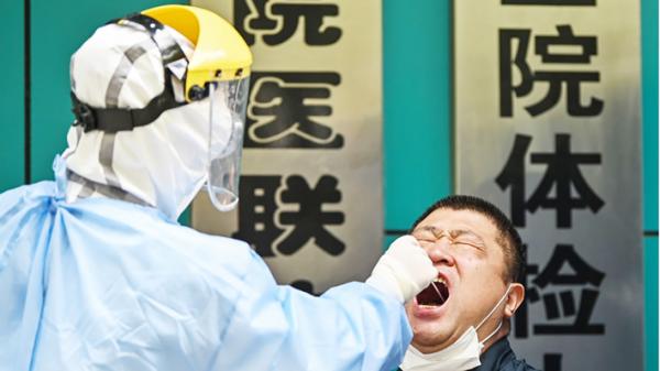 近日一名医务人员在武汉市抽取棉签样本。（Getty Images）