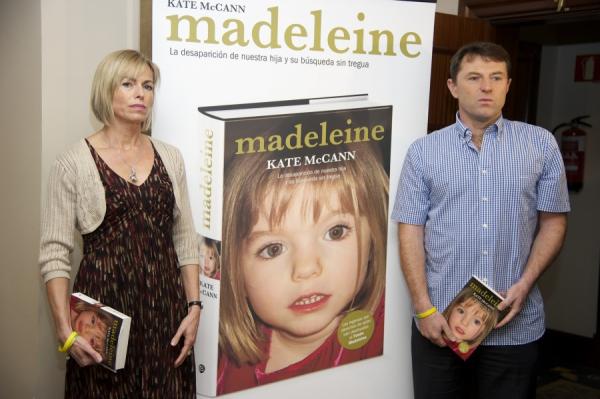 失踪女童的母亲Kate（左）和父亲Gerry（右），中间小女孩的照片是小玛德琳失踪时的模样。（图片来源：Carlos Alvarez/Getty Images）