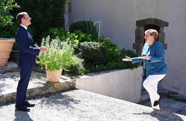 法国总统马克龙（左）在法国总统度假地布雷冈松堡接待了到访的德国总理默克尔（右）。（CHRISTOPHE SIMON/POOL/AFP via Getty Images）