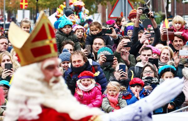 与往年圣尼古拉斯到来时有数千名小孩子和父母们迎接的不同，今年受疫情影响，孩子们无法到现场观看。图为：圣尼古拉斯在2019年11月16日抵达荷兰中部阿珀尔多伦（Apeldoorn）后受到民众热情的欢迎。（VINCENT JANNINK/ANP/AFP/Getty Images)