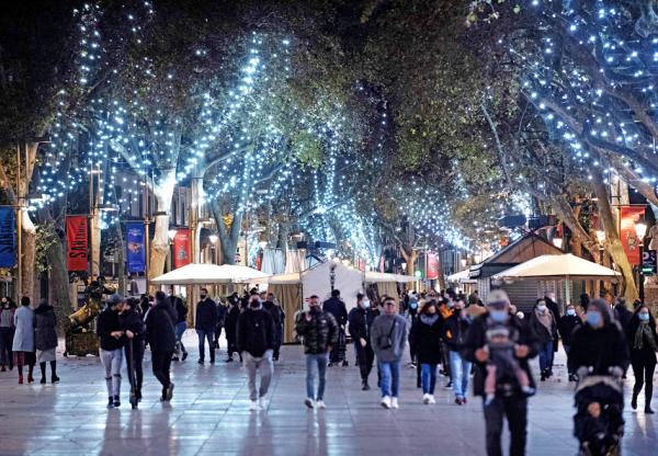人们在巴塞罗那圣诞灯展示街上行走。今年的圣诞节因疫情不同以往。（JOSEP LAGO/AFP via Getty Images）