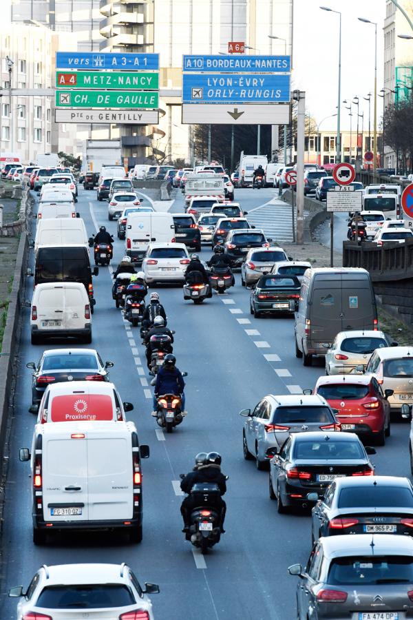 巴黎环城大道上，摩托车穿行在两排汽车间。（BERTRAND GUAY/AFP via Getty Images）