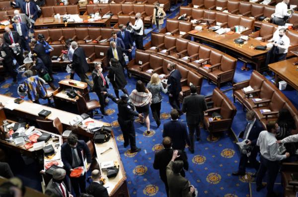 1月6日，美国国会受到不明身份抗议人士的冲击，会议暂停，国会大厦里的议员被维安人员急忙疏散。（Drew Angerer/Getty Images）