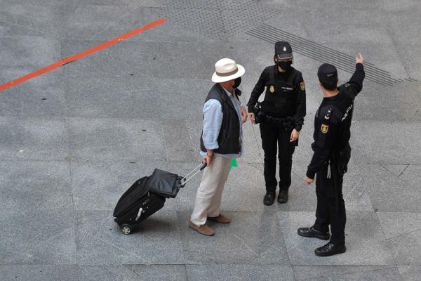 马德里一行人和警察对话。复活节期间，各大区边境关闭。（OSCAR DEL POZO/AFP via Getty Images）