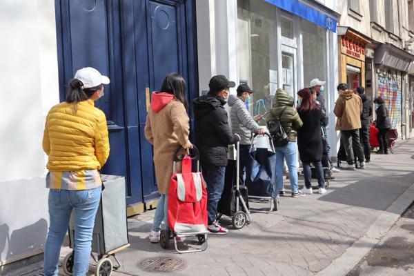 在法国温州旅行社门口排队等待领取爱心物资的华人