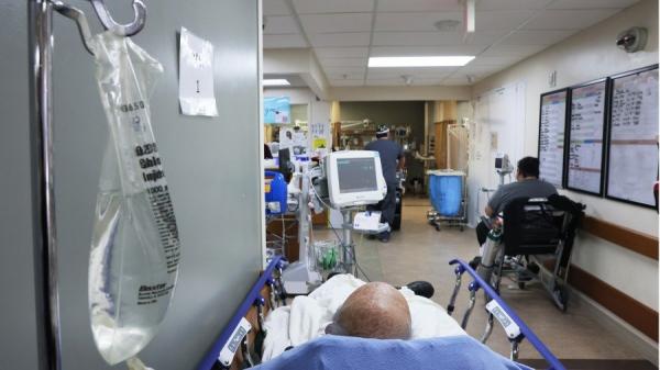 图为一名染疫病人在医院病床上休息。（图片来源：Mario Tama/Getty Images）