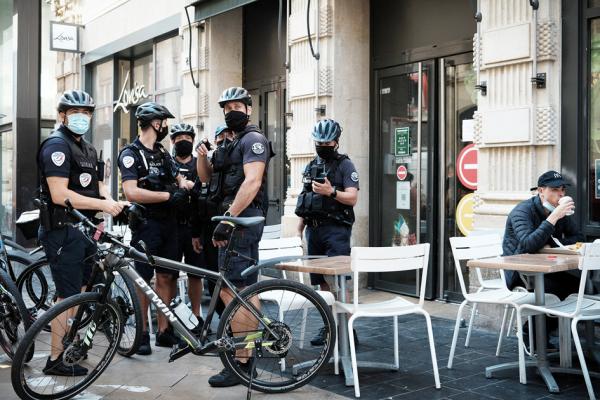 2021年8月11日，在法国西南部的波尔多，警察在一家快餐店外检查健康通行证。（PHILIPPE LOPEZ/AFP via Getty Images）