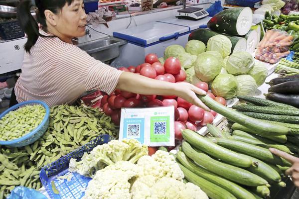 中国江苏省南通市某菜市场，商贩提供支付宝和微信二维码在线支付。（STR/AFP via Getty Images）