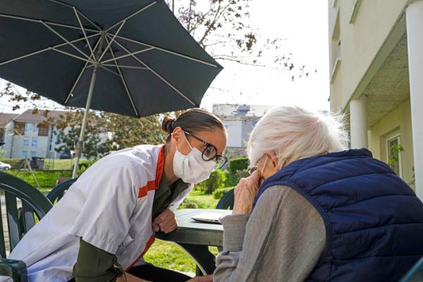 一位医护人员询问住在养老院的老人（SEBASTIEN BOZONAFP via Getty Images）